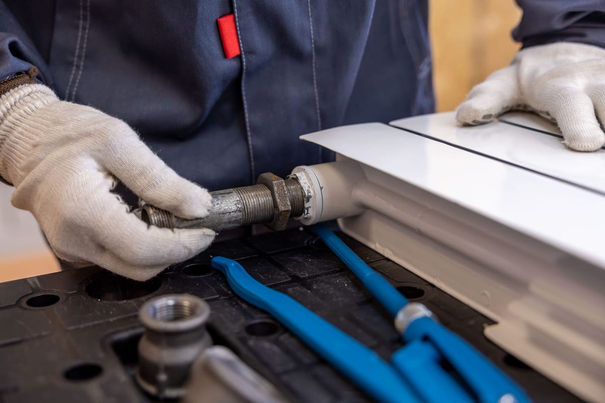Plumber's hands connecting a braided supply line during an installation